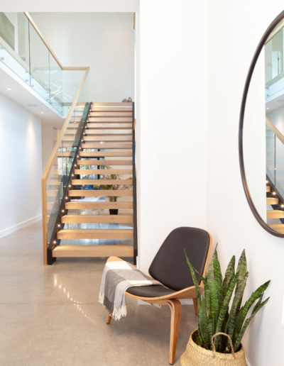 Open staircase with glass railing and natural light in modern Whistler home