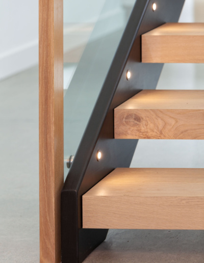 Modern staircase with wood steps and metal railing in Whistler Passive House