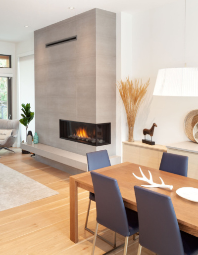 Open concept living and dining area with modern fireplace and mountain views in Whistler custom home