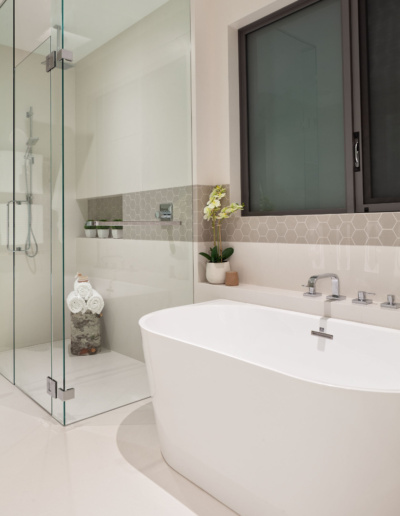Luxury white bathroom with glass shower enclosure and marble tile in Whistler custom home