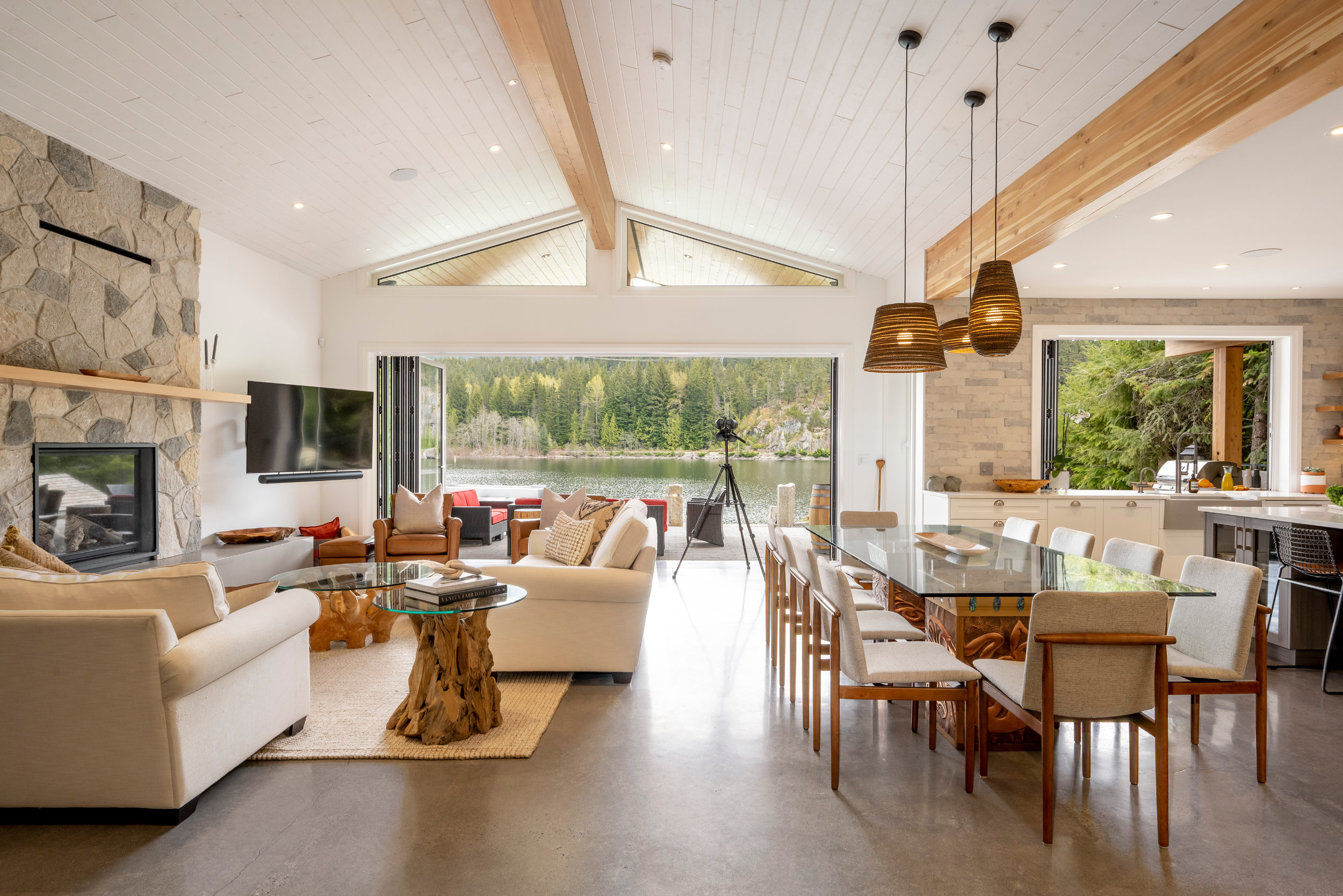 Vaulted Living Dining Space - Waterfront Retreat Open concept living and dining area with vaulted ceiling and skylight in Whistler lakefront home