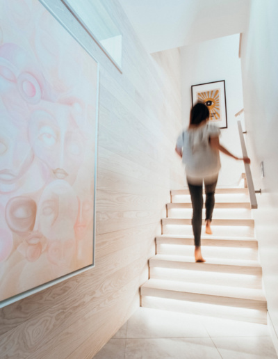 Person ascending contemporary staircase in renovated Whistler home