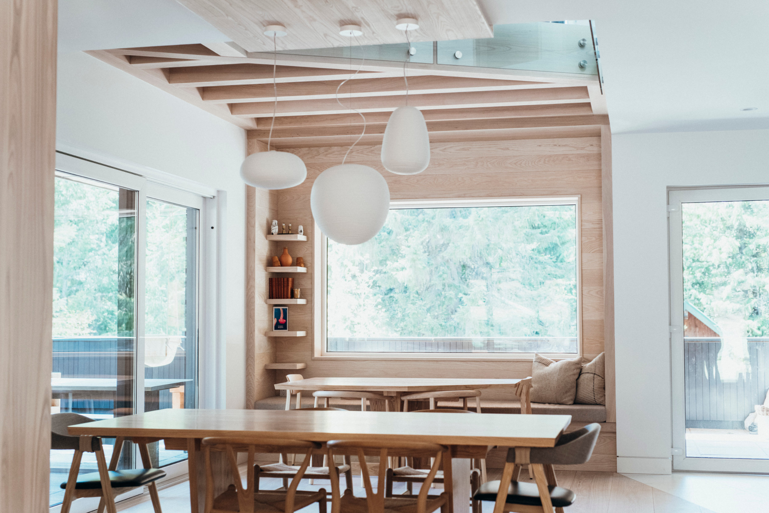 Dining Space with Window Seat - Whistler Living Dining area with built-in window seat and pendant lights in Whistler renovation