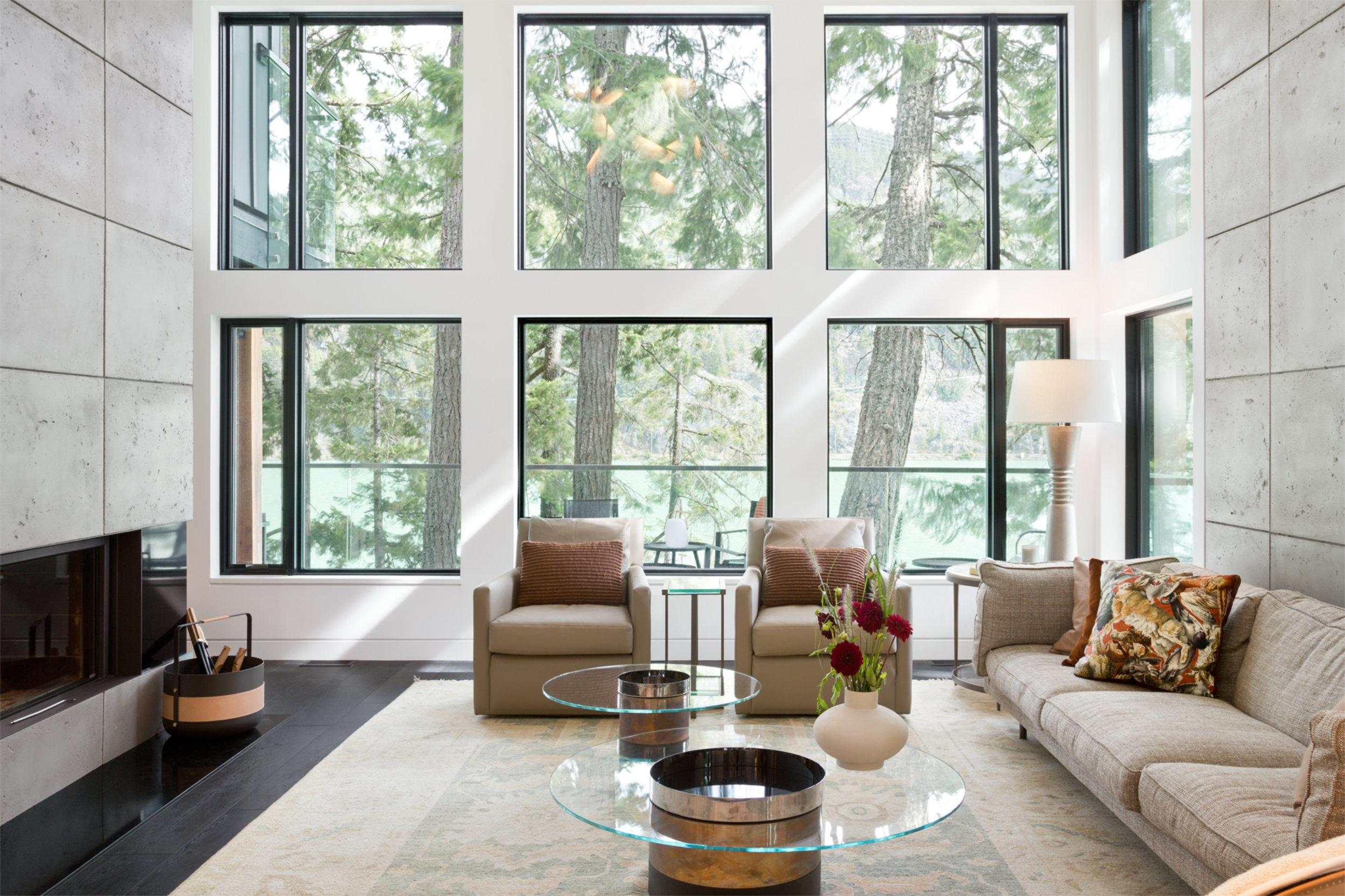 Living Room with Window Wall - Emerald Light Living room with floor-to-ceiling windows and mountain views in Whistler custom home