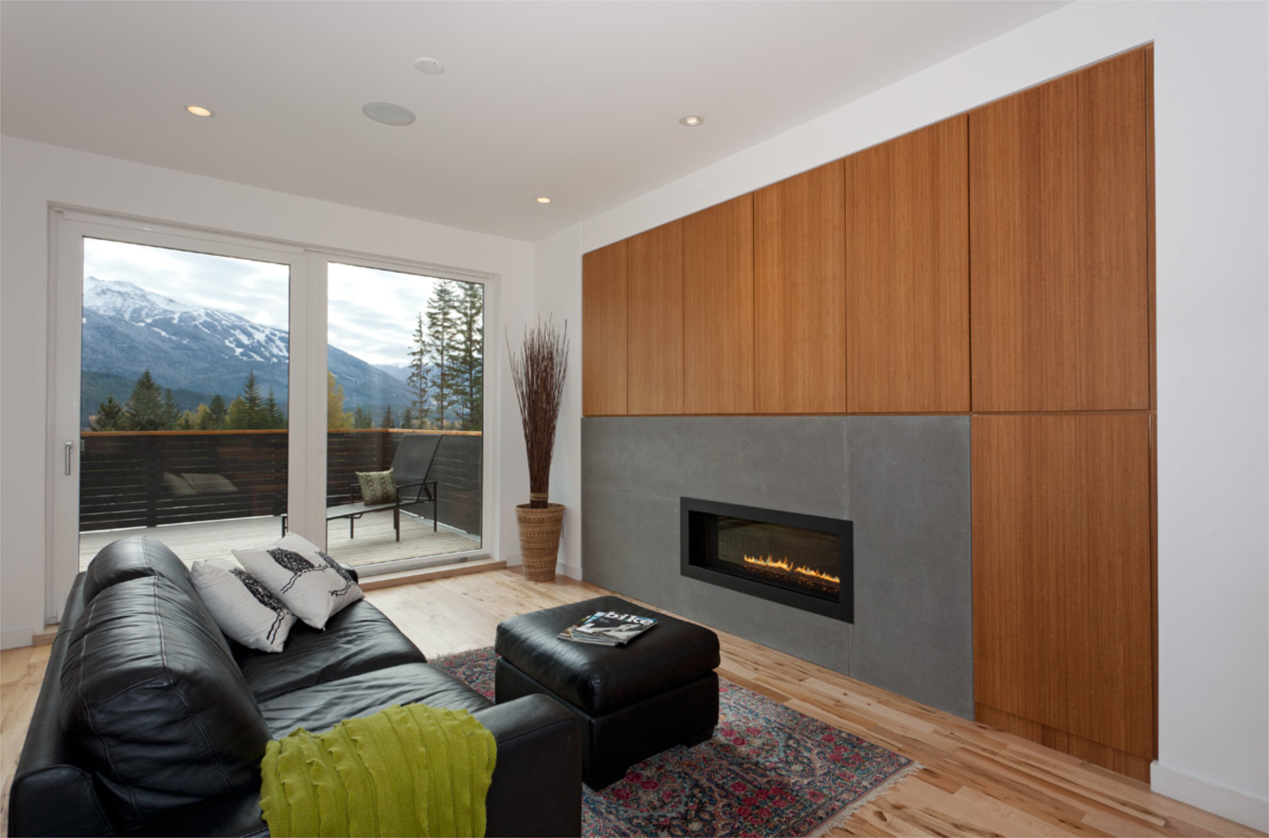 Living Room with Fireplace Wall - Rainbow Living room with wood accent wall, modern fireplace, and mountain views in Whistler home