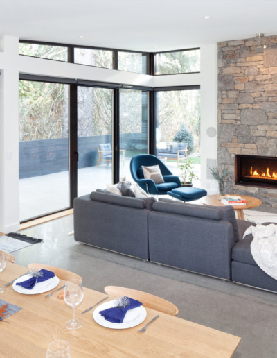 Contemporary kitchen with dining area and wood cabinetry in energy-efficient Whistler home