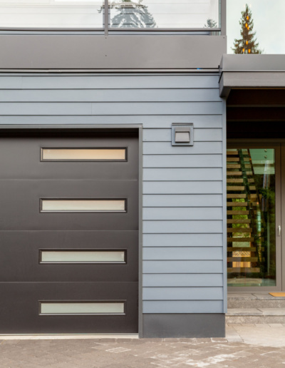 Contemporary front entrance with horizontal slat door and stone accents in Whistler custom home