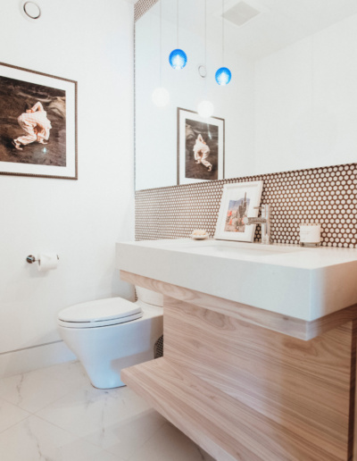 Modern bathroom with penny tile backsplash, floating wood vanity, and blue pendant lights in Whistler renovation