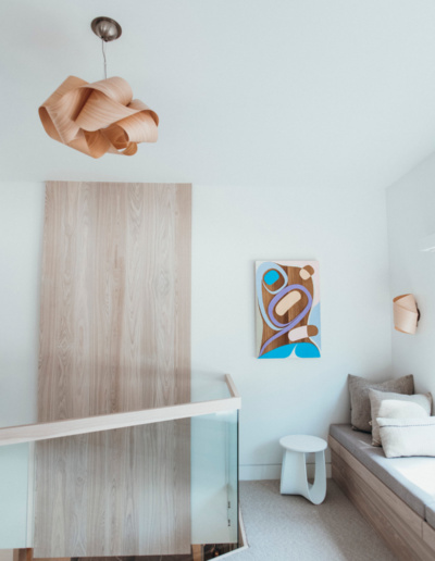 Loft area with sculptural wood pendant light and built-in storage in Whistler renovation